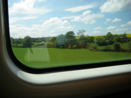 Flowers bloom in a distant field. On the rail from MCR to LDN, journal resting open, collecting my thoughts after three months of living in England.
