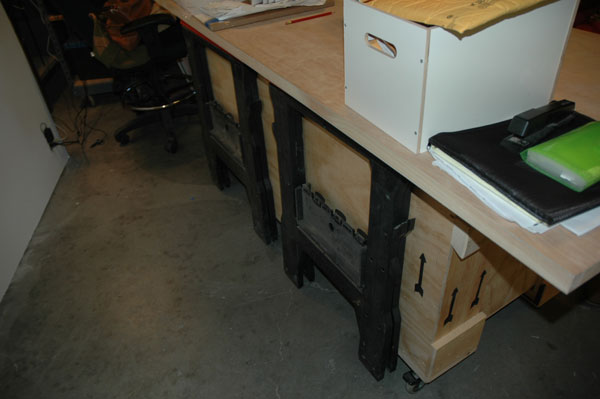 Free crate + casters + door + sawhorses = two tables that fold into one. Genius.