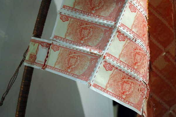 Hand stitched currency, and a staff made of stacked coins. Unidentified artist, Baró Gallery, São Paolo.