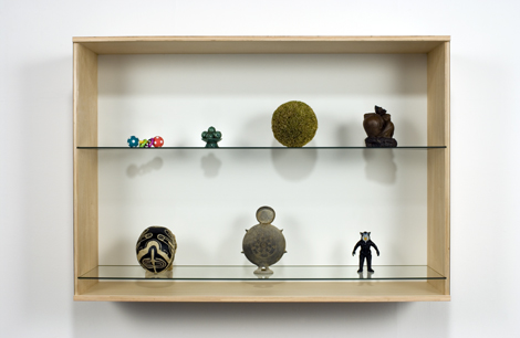 Haim Steinbach, Untitled (skull, vessel, figurine, toy, fruit bowl, sphere, peasant), 2006  Birch plywood, plastic laminate and glass box; synthetic polymer skull; Korean ceramic vessel; plastic figurine; plastic baby toy; Chinese fruit bowl; straw ball; Chinese ceramic statuette 37-3/4 x 53-3/4 x 14-3/4 in. (95.8 x 136.6 x 37.5 cm) // Source: HaimSteinbach.net.