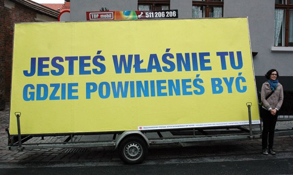 Susan O'Malley with her mobile billboard stating "You Are Exactly Where You Need to Be" in the Art Moves Festival in Torun, Poland, September 2012.