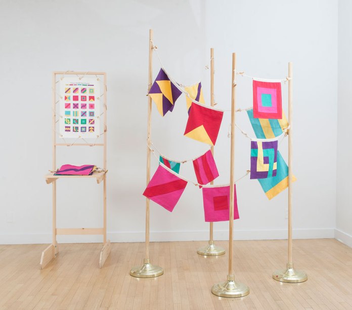 Christine Wong Yap, Character Strengths Signal Flags, 2015, linen, twill tape, letterpress-printed ribbon, rope, wood, flagpoles; 24 flags: 12.5 x 12 inches each; edition of three; flagpoles: 72–84 x 12 x 12 inches each; display: 73.5 x 20.5 x 27 inches. Photo: Anna Ablogina.