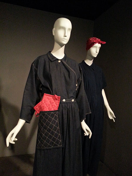 Front: Reproduction of Claire McCardell's "Popover" dress, circa 1942, blue denim and red cotton. Also: denim jumpsuit, as women joined manufacturing for WWII.